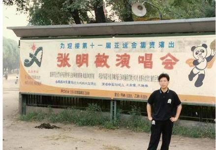 张明敏在巡回演唱会海报前